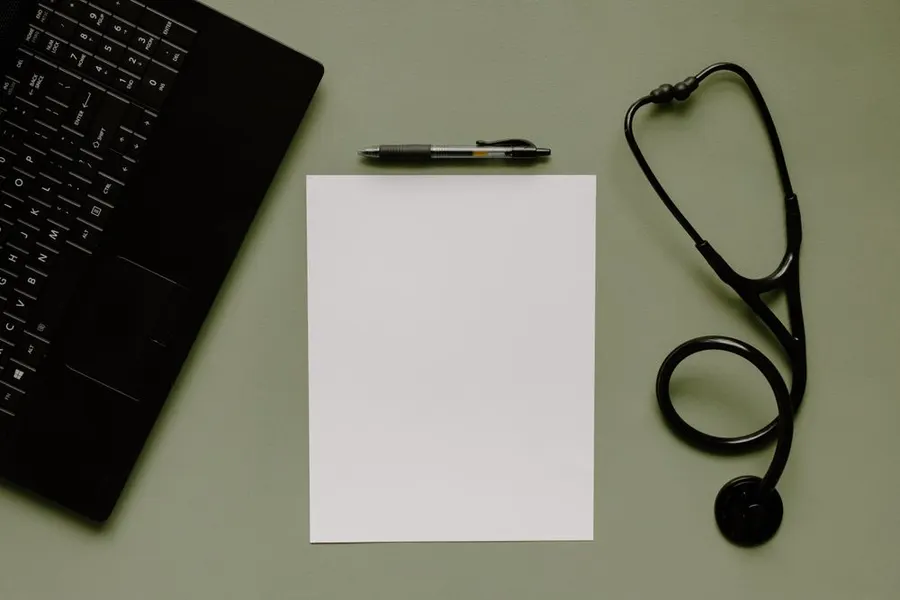 Un fonendoscopio y un bloc de notas sobre la mesa de una consulta