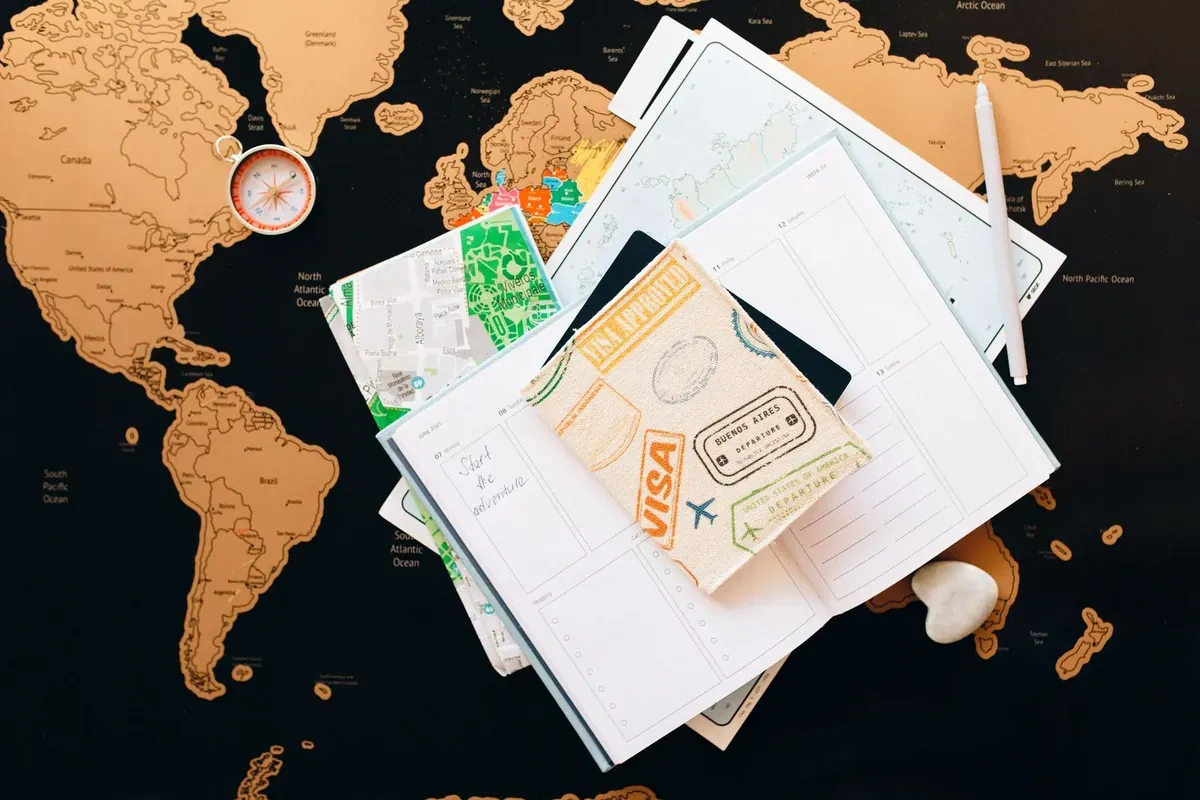 Documentos de viaje y un pasaporte extendidos sobre un mapa