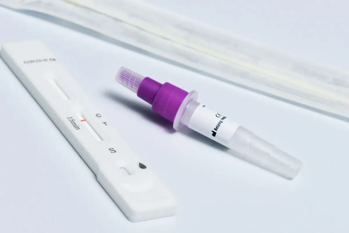 Un casete de test rápido de antígenos y un hisopo sobre una superficie blanca