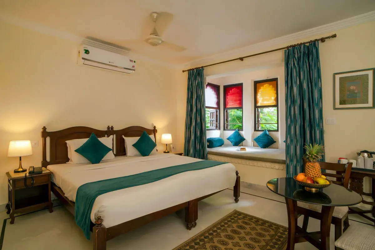 Una habitación de hotel arreglada, con la cama junto a la ventana